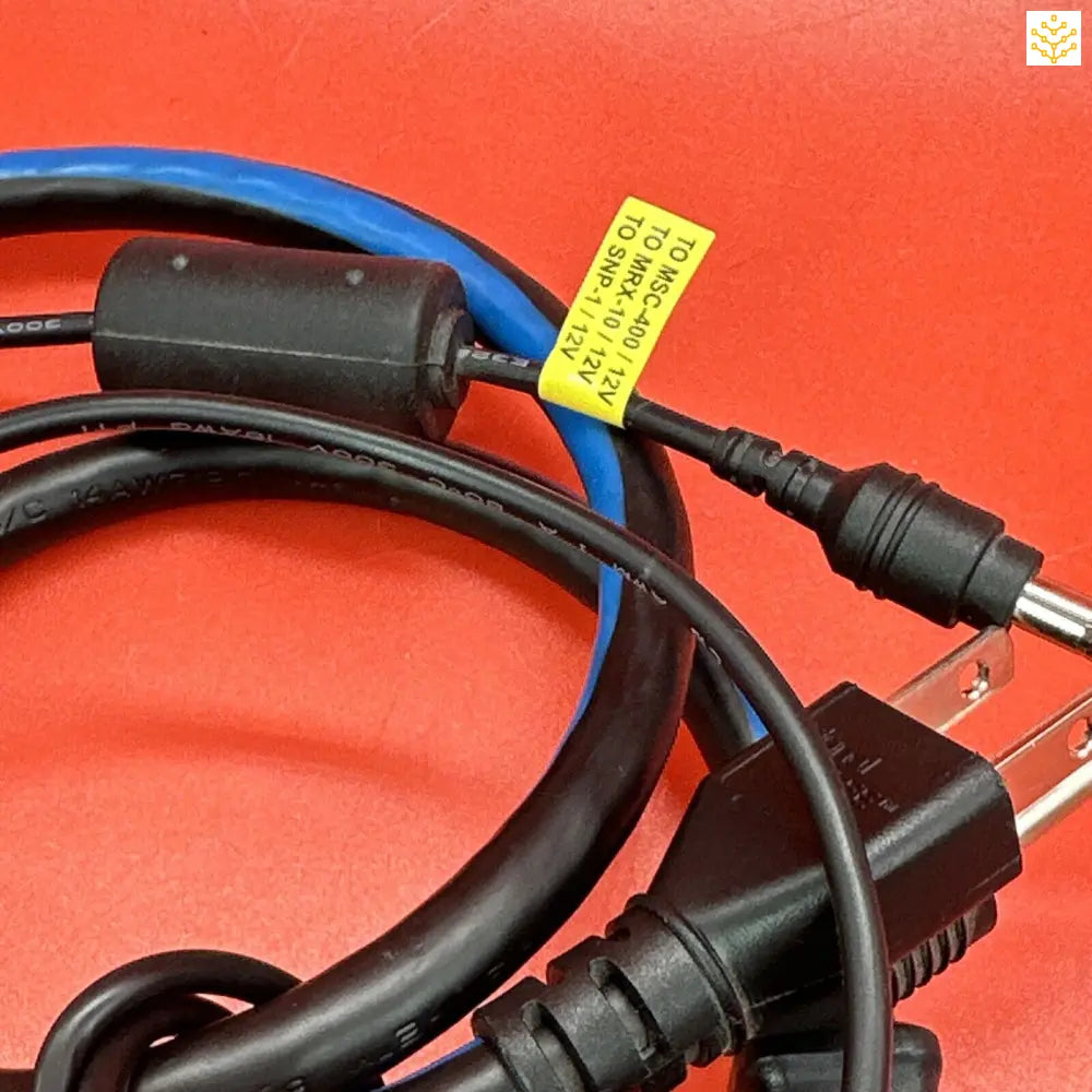 Power cable with multiple connectors and a yellow warning label attached.