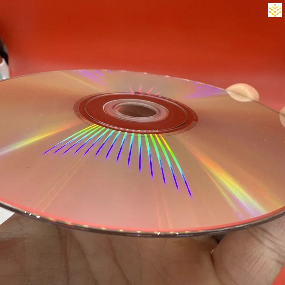 Compact disc (CD) displaying rainbow light diffraction patterns across its surface.