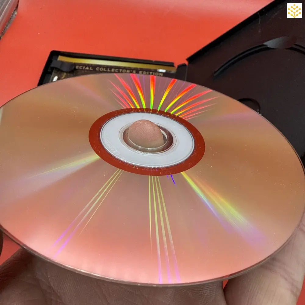 Shiny DVD or CD disc with rainbow light reflections across its surface.