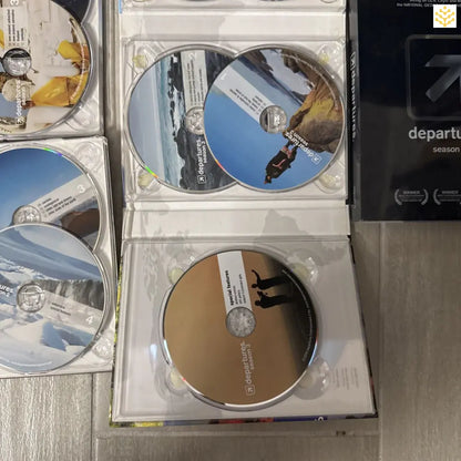 Collection of DVDs or CDs in clear plastic cases.