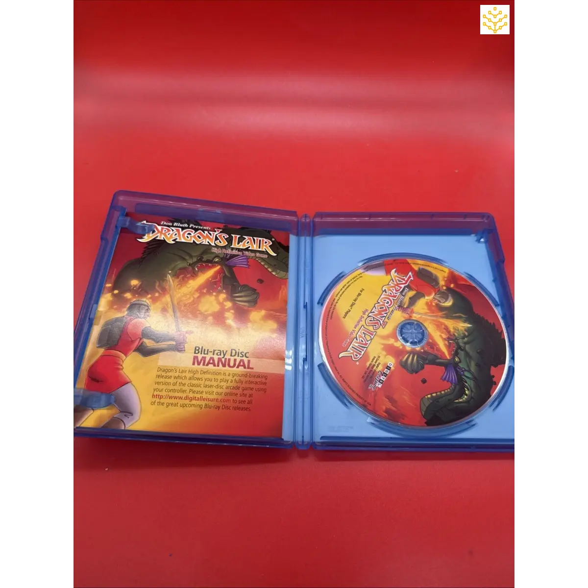 Blu-ray disc case for ’Dragon’s Lair’ video game opened to show the disc and manual inside.