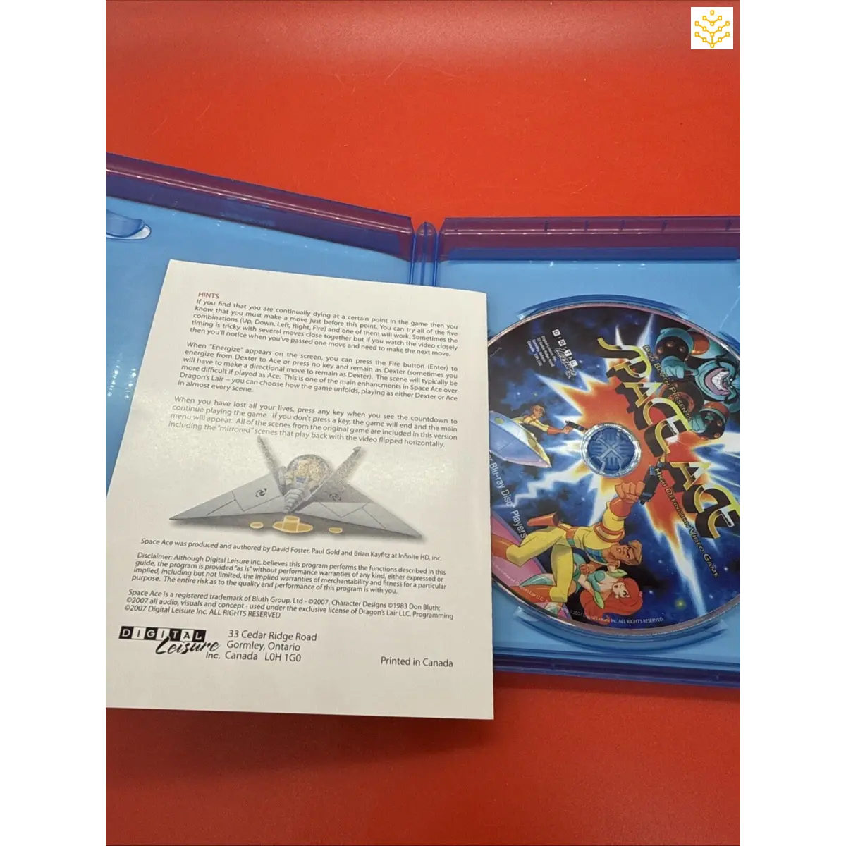 Open Blu-ray case containing a disc and an informational booklet or insert.