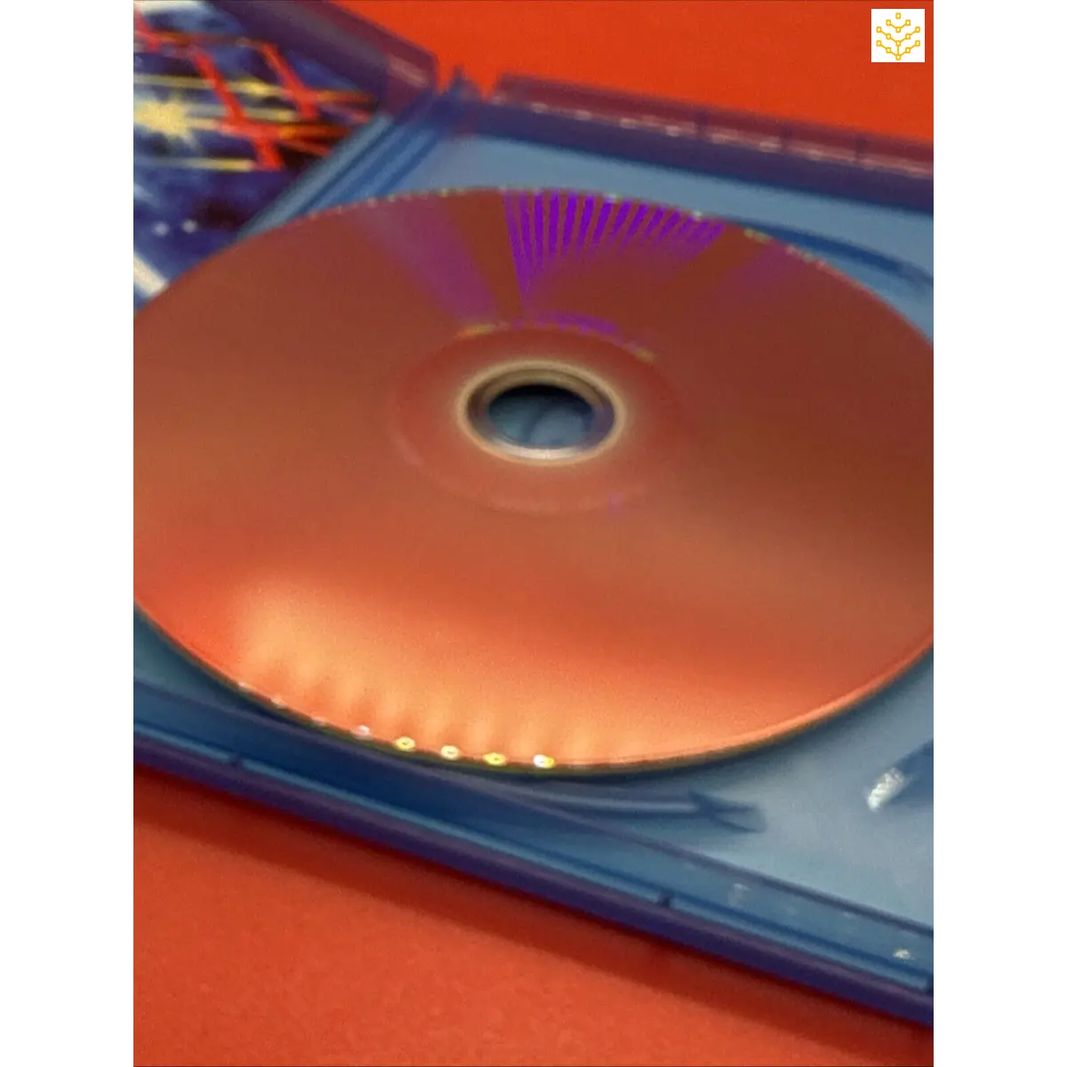 Compact disc (CD) partially inside a blue plastic case.