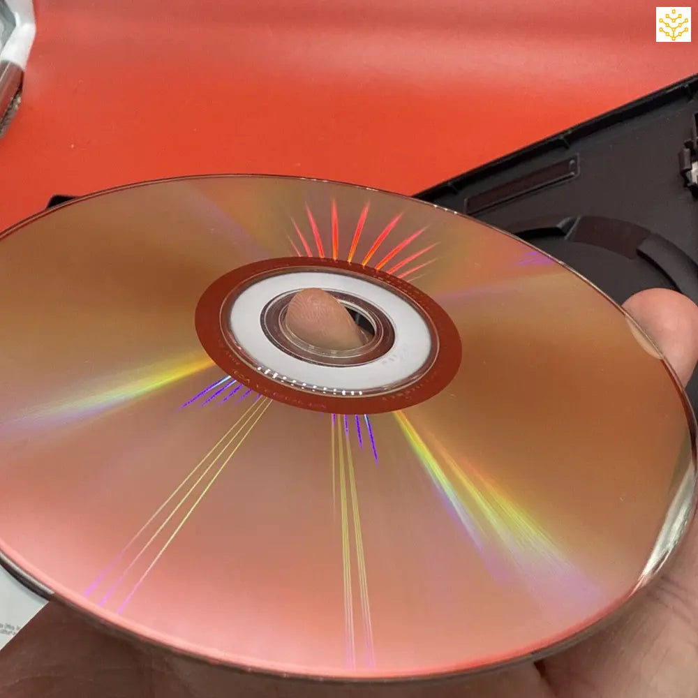 Shiny DVD or CD disc displaying rainbow light reflections across its surface.