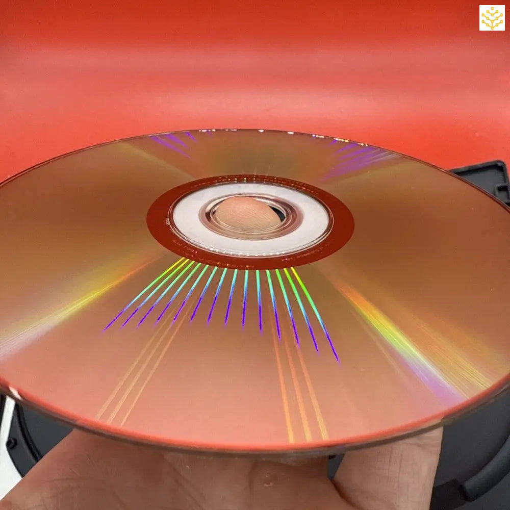 Gold-colored optical disc displaying rainbow light reflections across its surface.