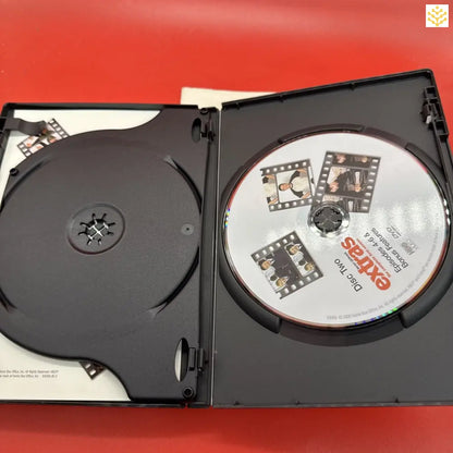 Open DVD case showing a disc and empty disc holder.