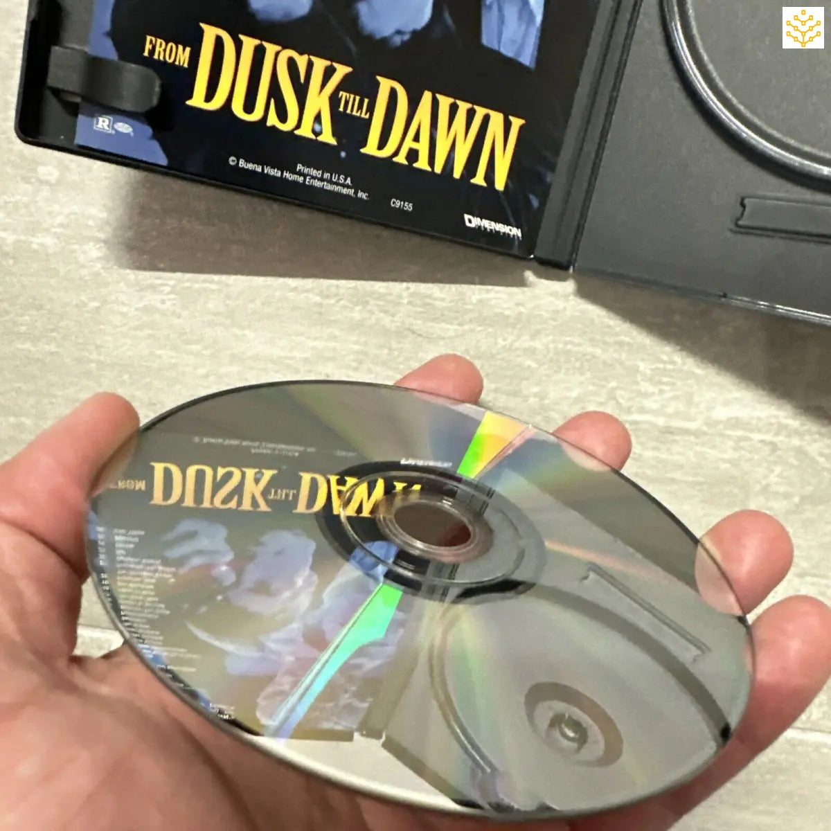 DVD or CD disc of the movie ’From Dusk Till Dawn’ held in a person’s hand.