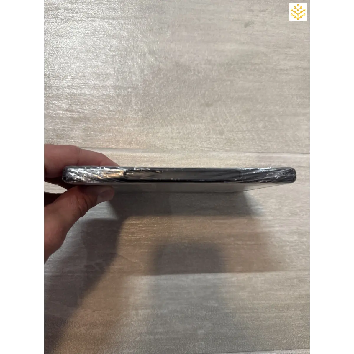 Damaged smartphone with a severely bent and cracked screen.