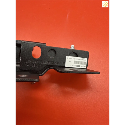 Black metal bracket or mounting plate with holes and a barcode label.