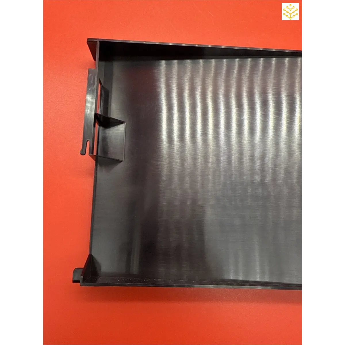 Black plastic tray with ridged metallic interior surface.