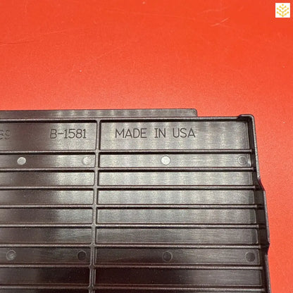 Black plastic grid or vent panel with ’MADE IN USA’ and ’B-1581’’ markings.