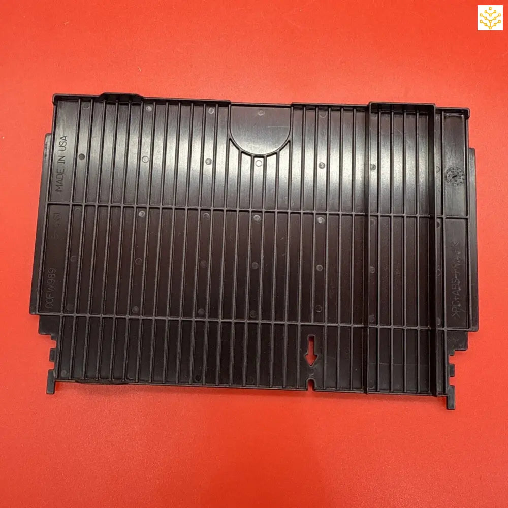 Black plastic printer paper output tray with vertical ridges.