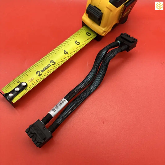 Yellow measuring tape alongside a black braided computer cable connector.