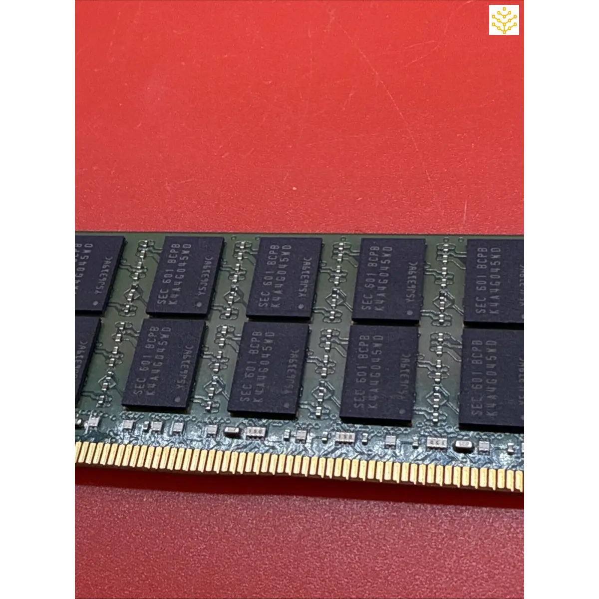 Computer RAM module with black memory chips mounted on a green circuit board.