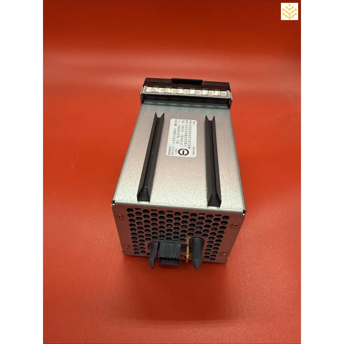 Power supply unit or computer power module with a metallic casing and ventilation holes.