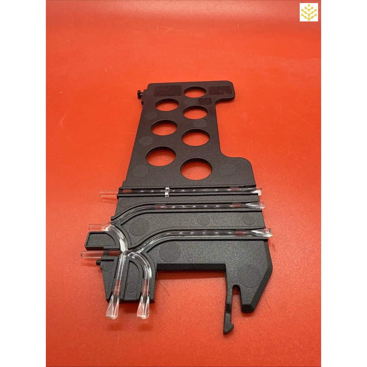 Black plastic track piece with multiple circular holes and curved rail sections.