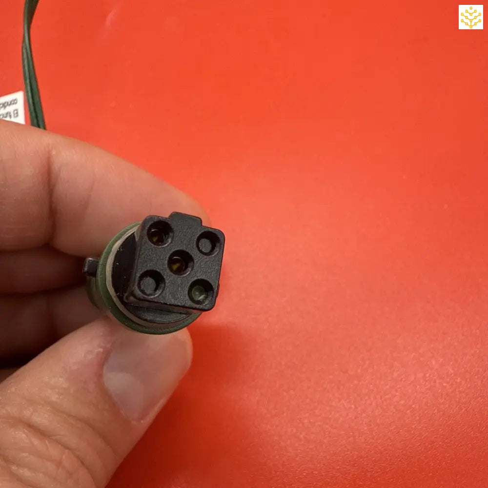 5-pin electrical connector or socket held between fingers.