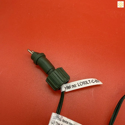 Dark green electrical connector with a white label attached.