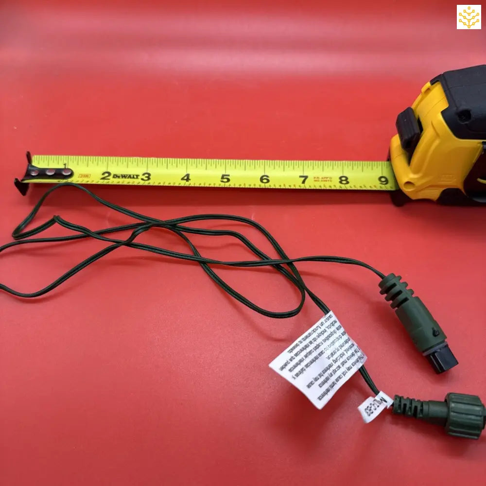 Yellow measuring tape with black markings and electrical cords.