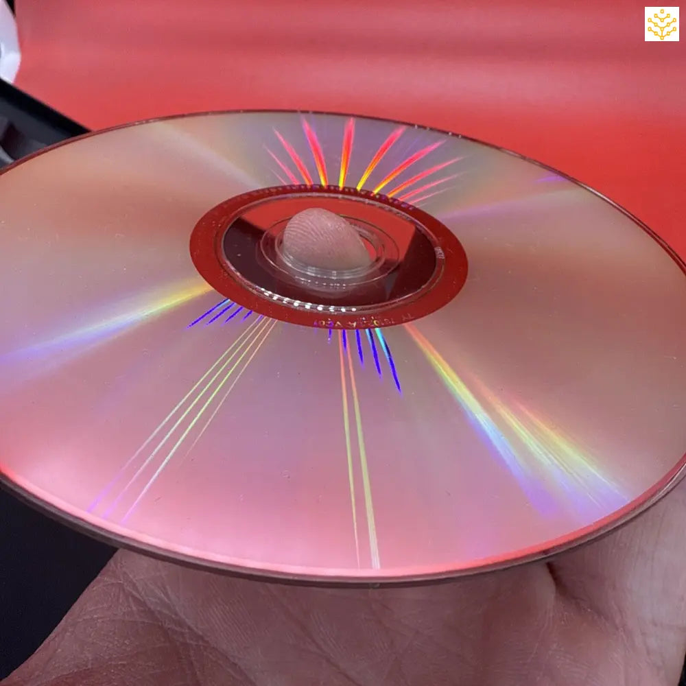 Scratched or damaged CD/DVD with rainbow light reflections across its surface.