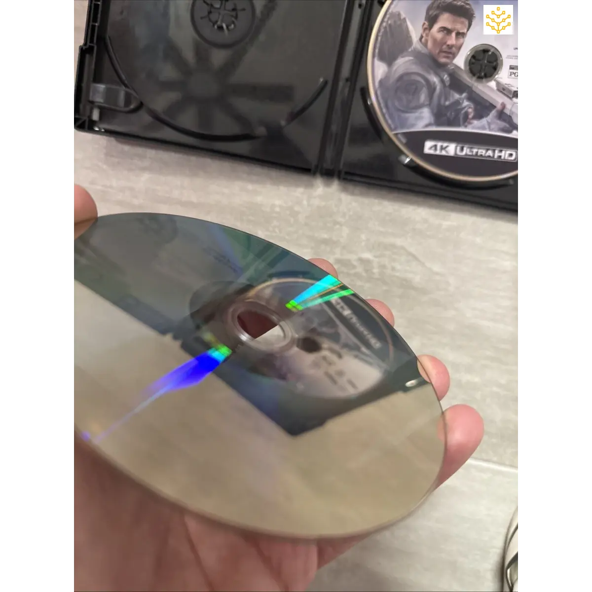 Cracked or damaged DVD or Blu-ray disc reflecting colorful light.