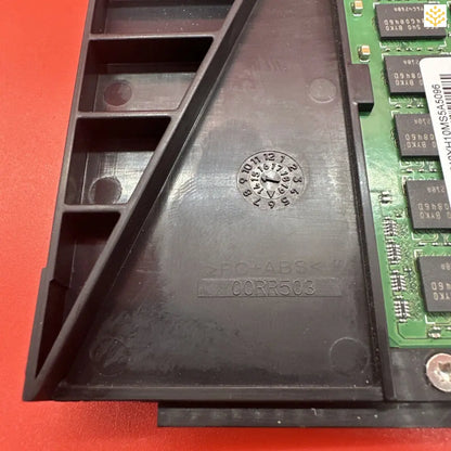 Black plastic computer or electronics component housing with a circular embossed pattern.