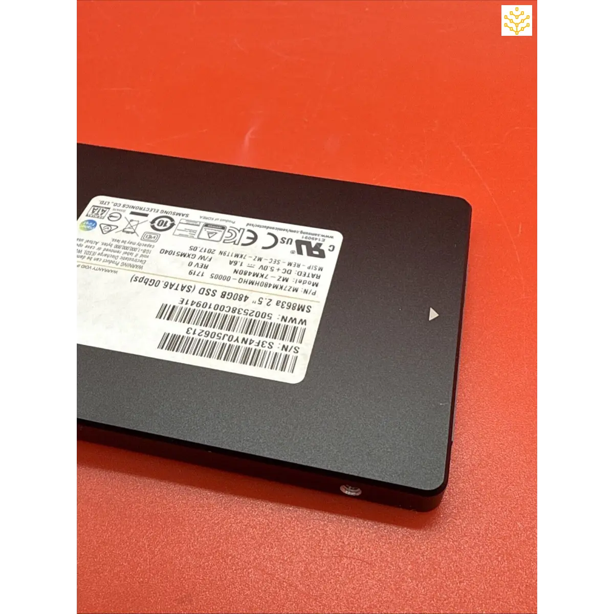 Solid state drive (SSD) with a product label affixed to its surface.