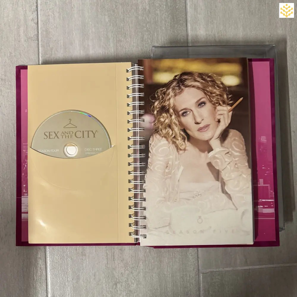 A Sex and the City DVD box set or collector’s book with a spiral binding and photo page.