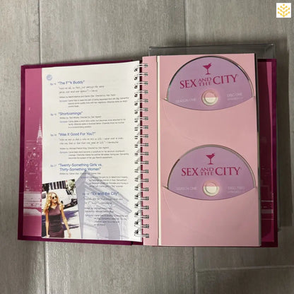 Open spiral-bound book showing ’Sex and the City’ DVD discs on the right page.