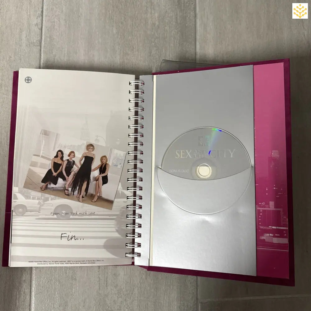 Open spiral notebook with a CD sleeve and photo on facing pages.