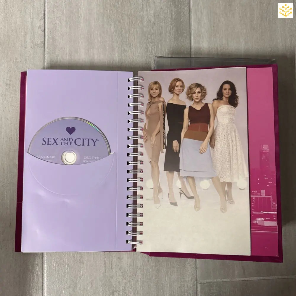 Pink spiral notebook featuring the Sex and the City logo and a group photo of four women.