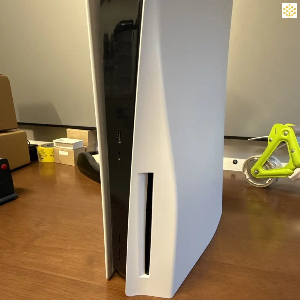 White PlayStation 5 gaming console positioned vertically.