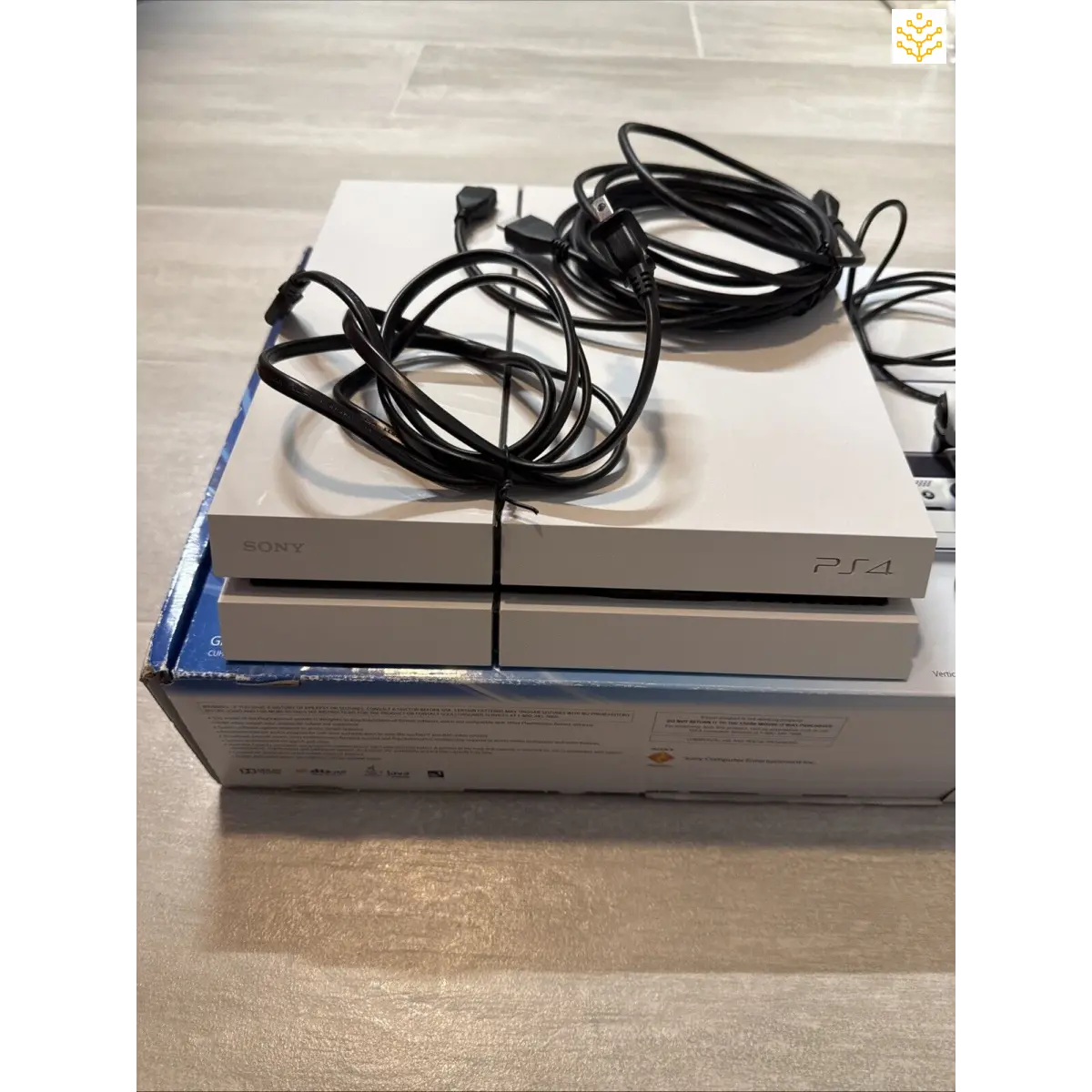 PlayStation 4 console with cables on top of its box.