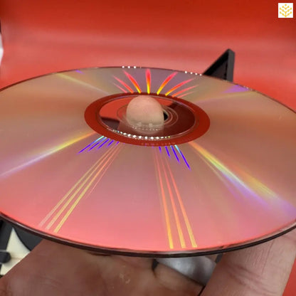 Compact disc (CD) with rainbow light reflections across its surface.