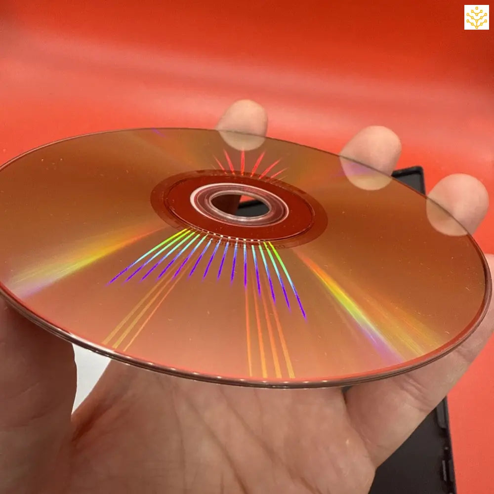 Gold-colored DVD or CD disc reflecting rainbow light patterns.