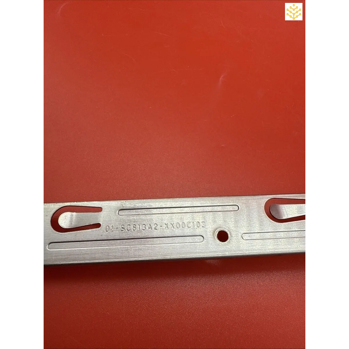 Metal bracket or mounting plate with slots and holes for attachment.