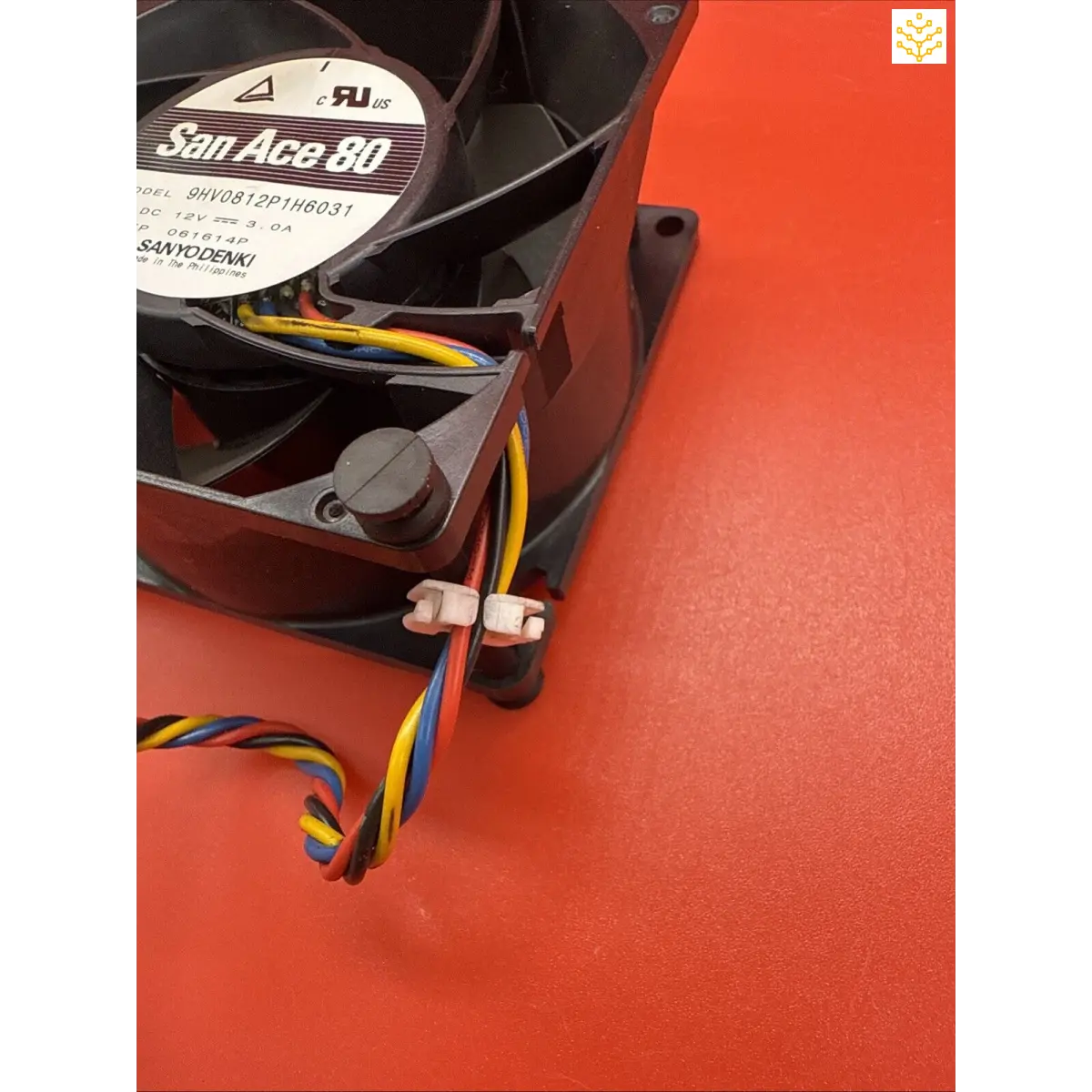 Computer cooling fan with colorful wires attached.