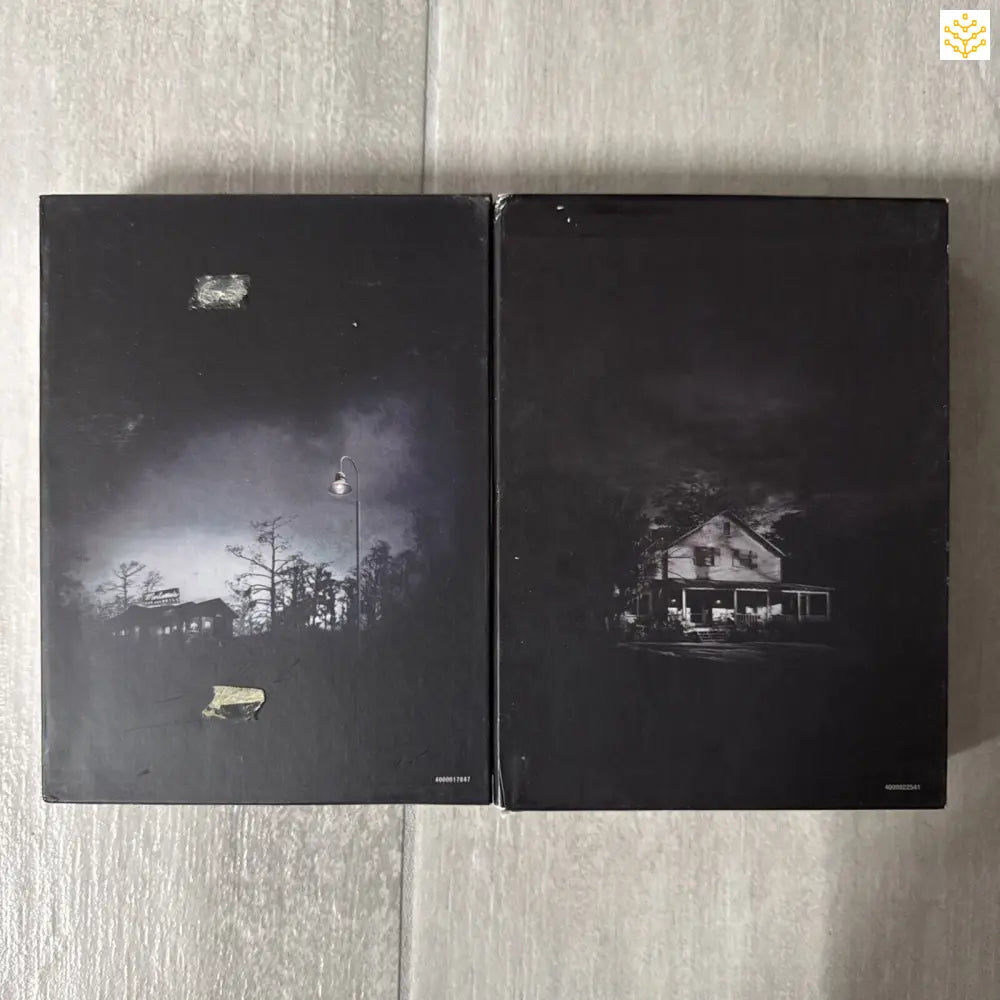 Two dark hardcover books with moody black-and-white nighttime scenes on their covers.