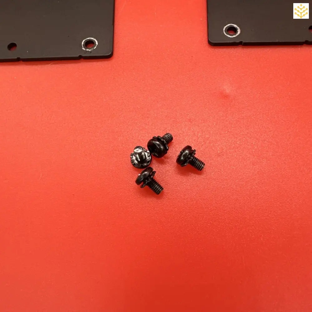 Small black screws or bolts on a red surface.