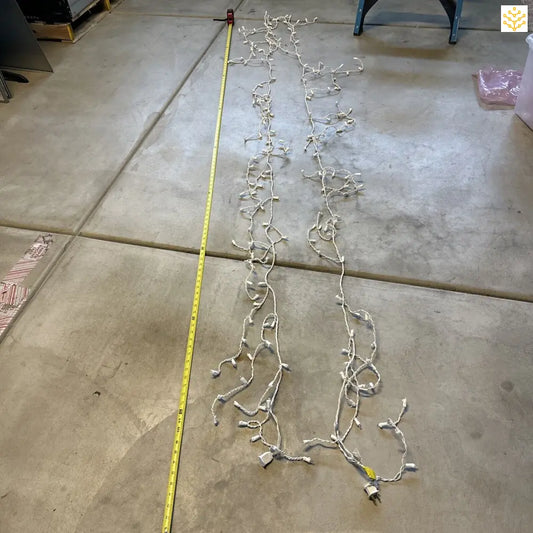 String of white Christmas lights laid out on a concrete floor.