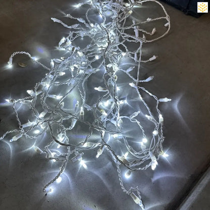 Tangled string of white LED lights glowing with a cool brightness.