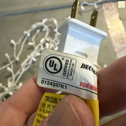 White and yellow electrical plug with a UL certification label.