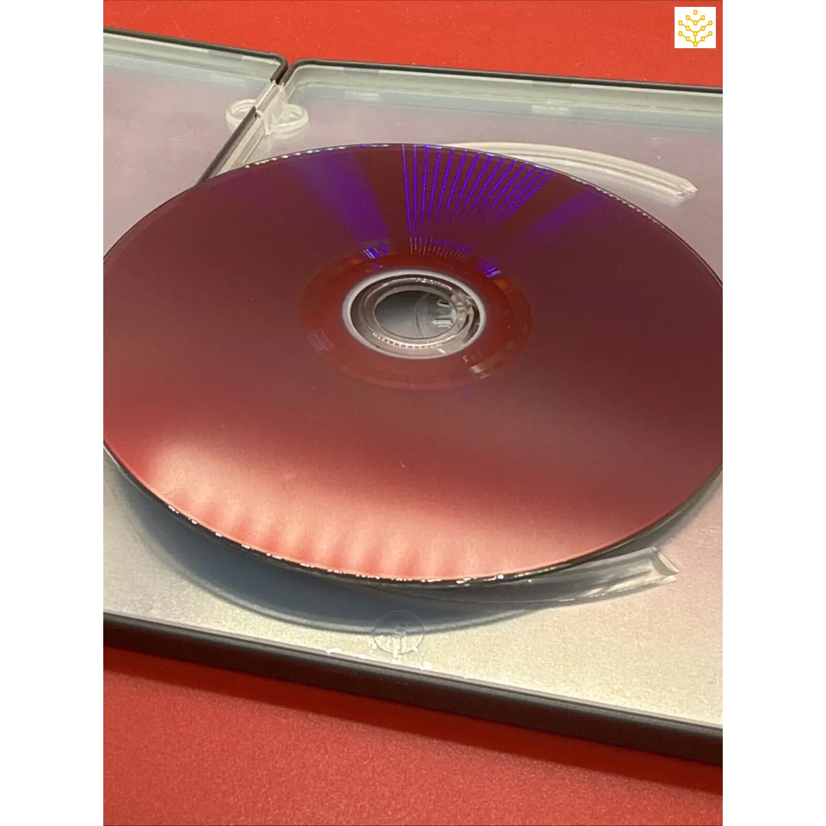 Compact disc (CD) with a purple-tinted reflective surface in a clear plastic case.