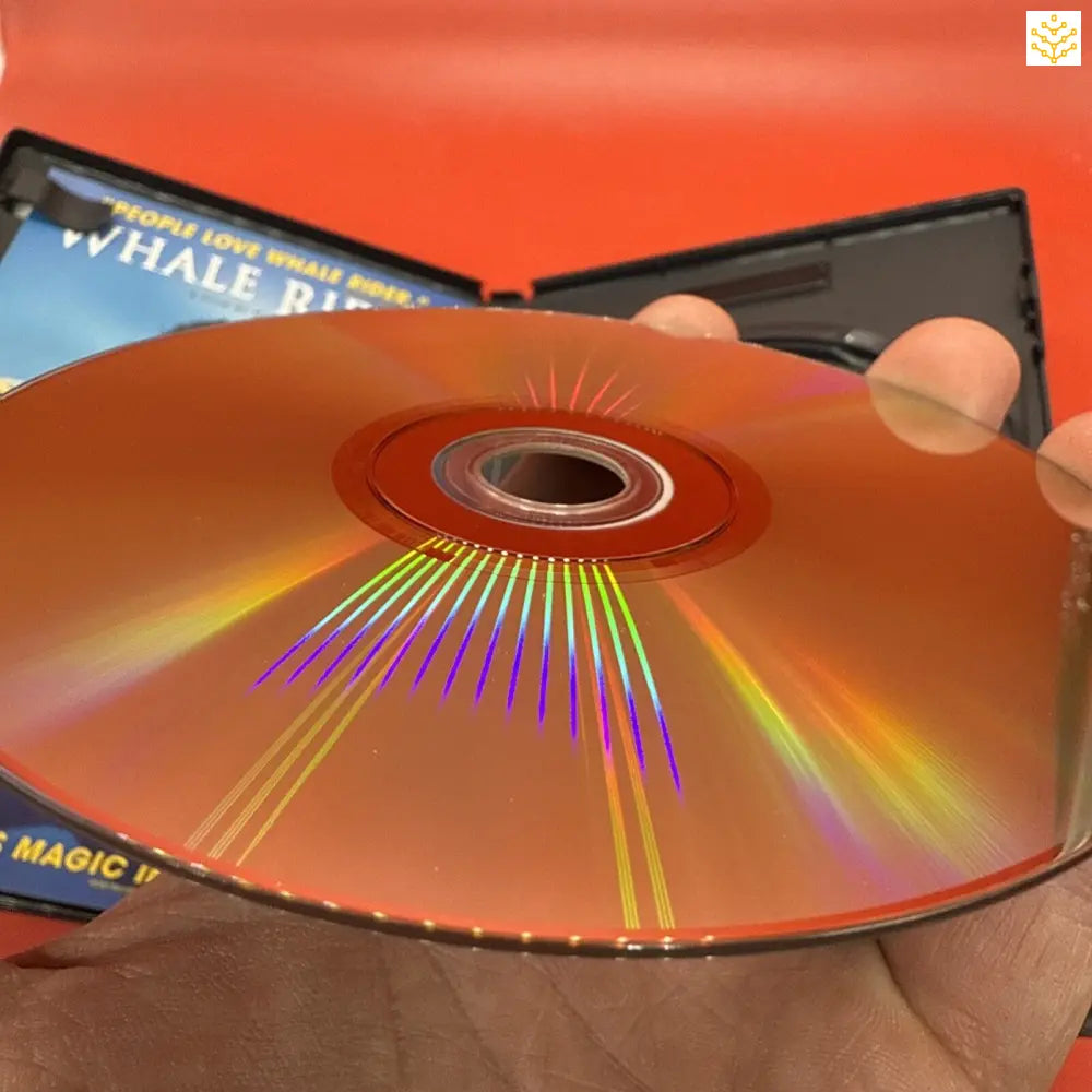 Shiny DVD or CD disc displaying rainbow light reflections across its surface.