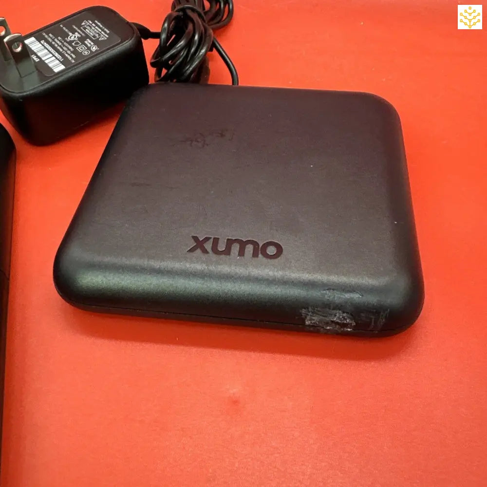 Black Xumo-branded electronic device with its power adapter.