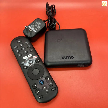 Xumo streaming device with its remote control and power adapter.