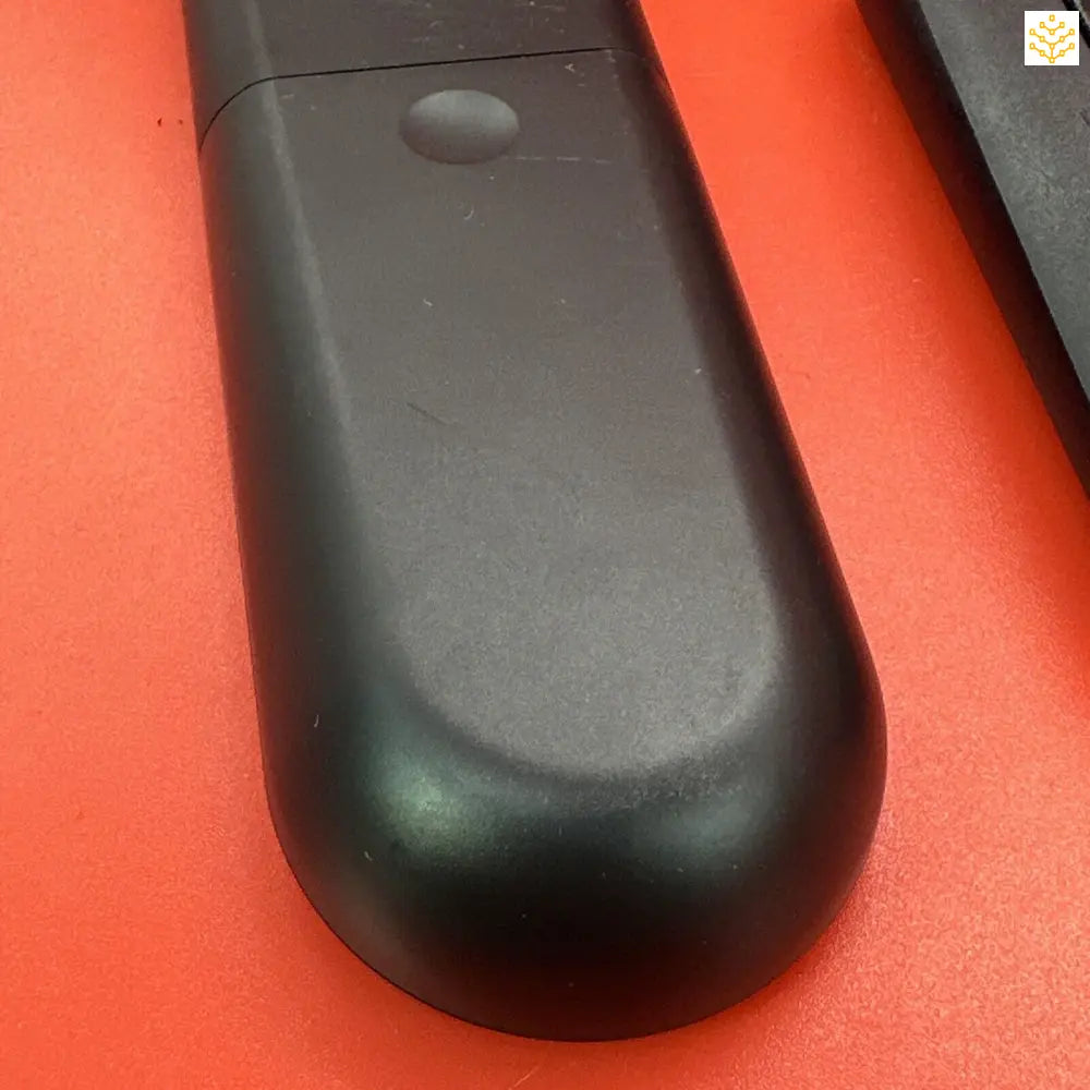 Black plastic remote control or electronic device with a curved, elongated shape.